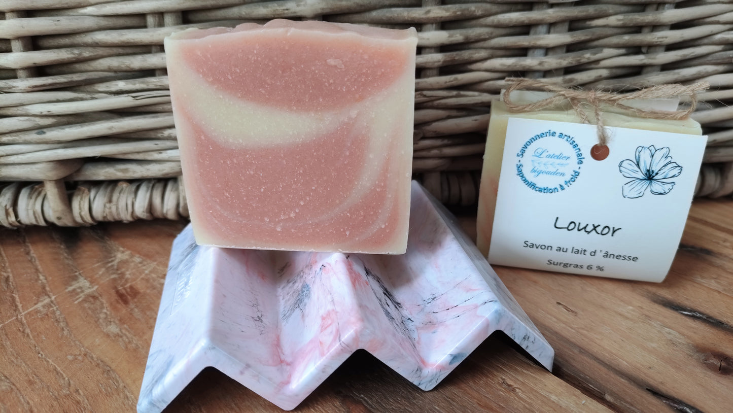 porte-savon en filet de pêche recyclé. forme en zig-zag couleur rose avec un savon posé dessus