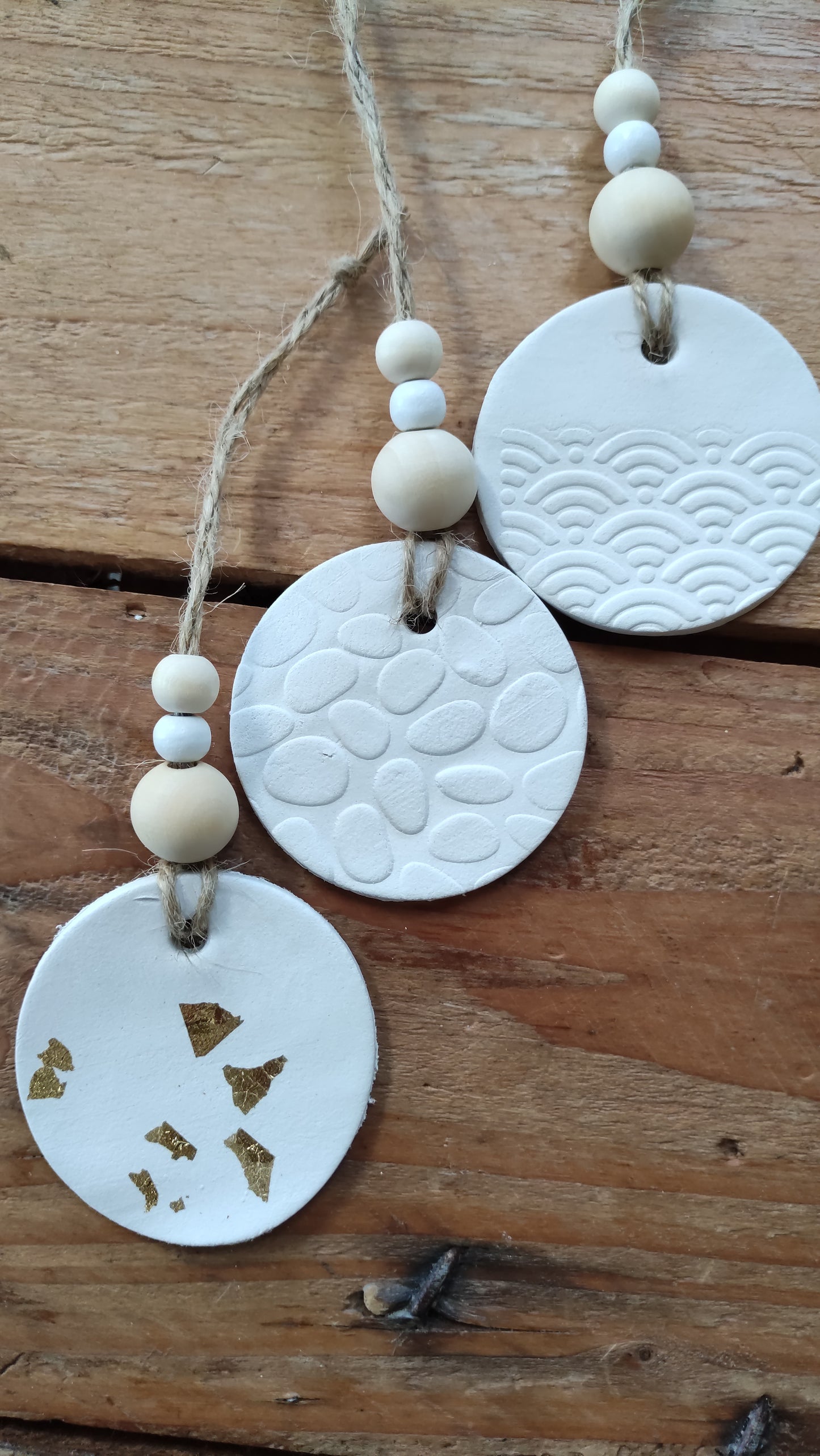 suspension ronde en argile blanche soutenue par une ficelle de chanvre avec 3 perles de bois aux tons naturels