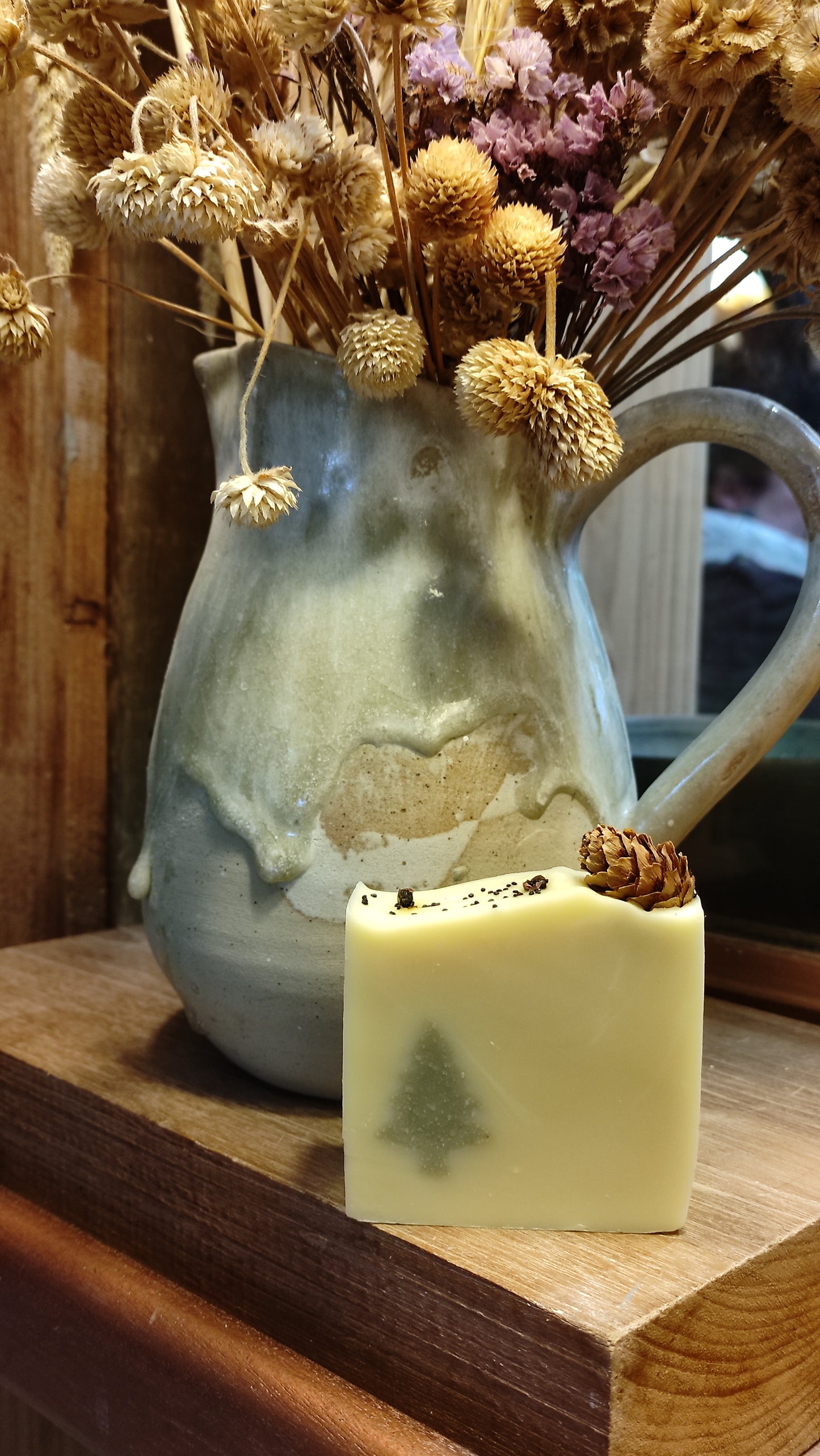 savon couleur crème avec insert sapin vert et avec petite pomme de pin sur le dessus et baies roses et graines de pavot - édition 2023