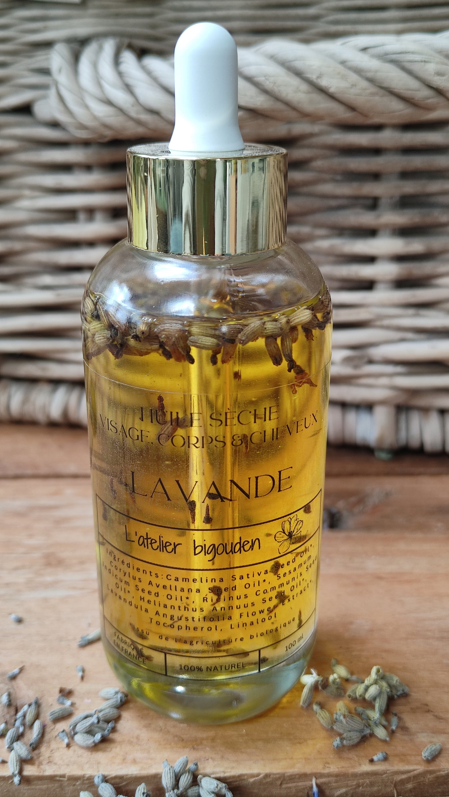 joli flacon en rondeur, transparent avec un bouchon compte-goutte doré. L'huile est jaune or avec des fleurs de lavande en suspension.