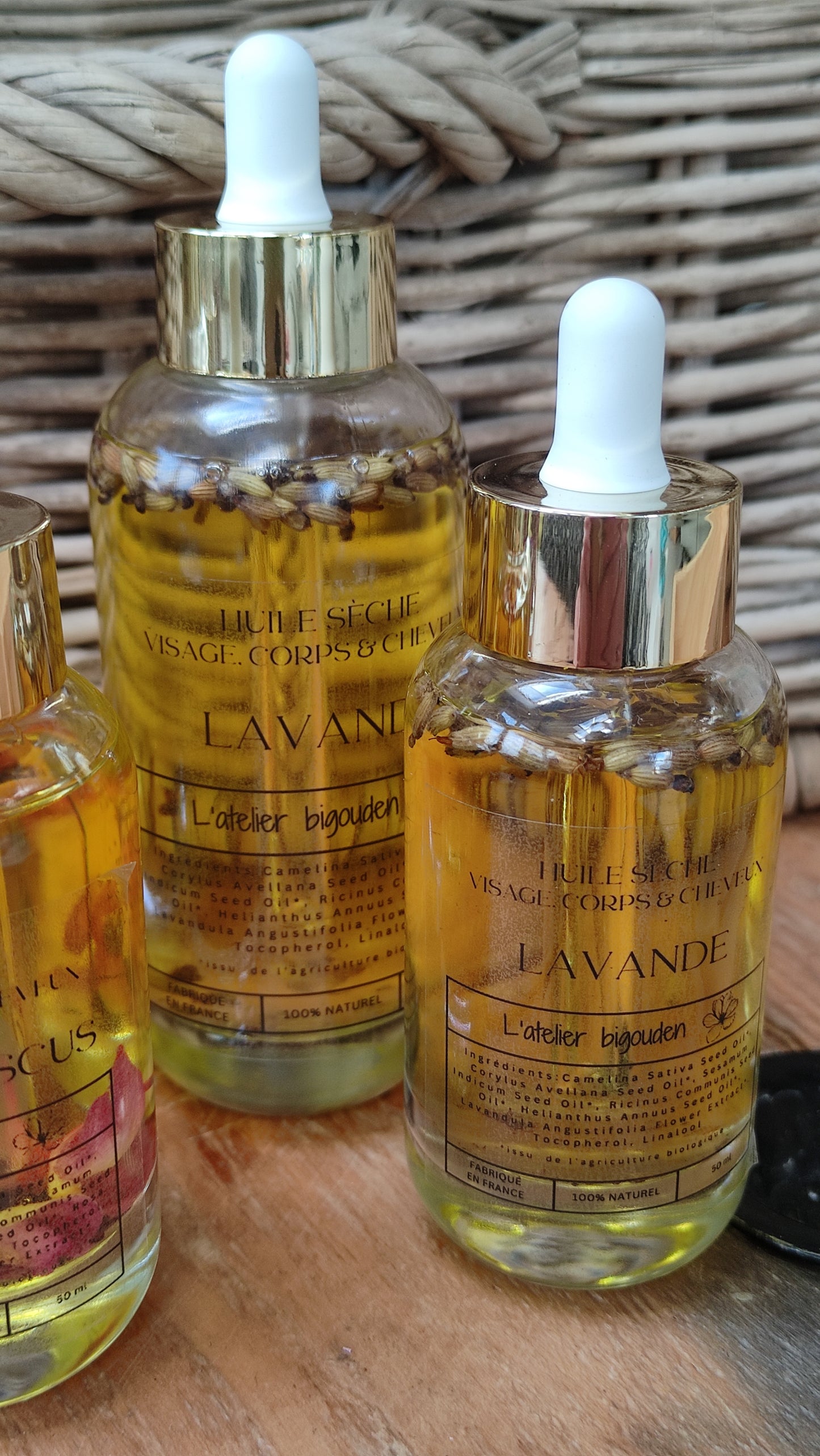 joli flacon en rondeur, transparent avec un bouchon compte-goutte doré. L'huile est jaune or avec des fleurs de lavande en suspension.