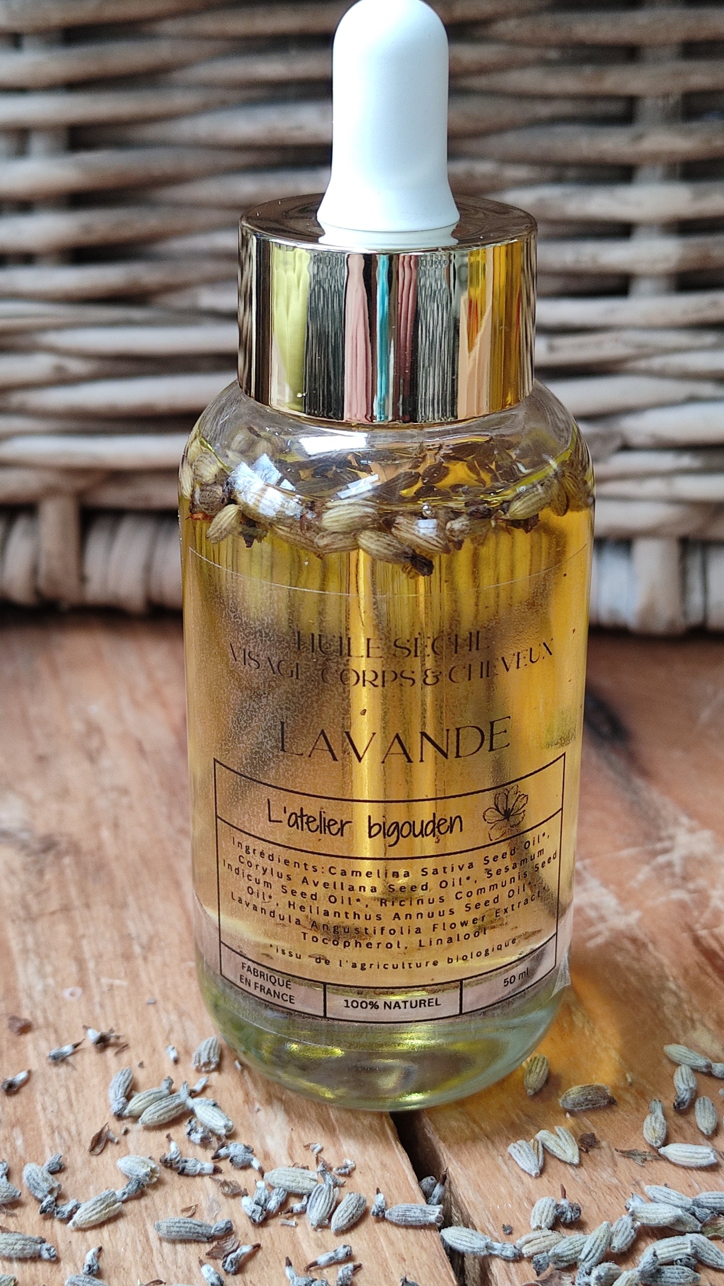joli flacon en rondeur, transparent avec un bouchon compte-goutte doré. L'huile est jaune or avec des fleurs de lavande en suspension.
