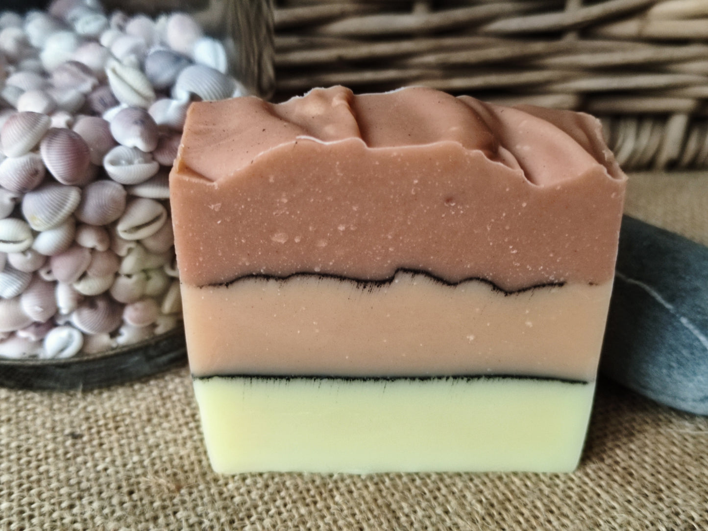 savon surgras saponifié à froid à l'huile de pépin de raisin. Il est composé de trois couches séparée par ne ligne de charbon. La première est couleur beige, la deuxième rose pâle et la dernière rose plus foncé.