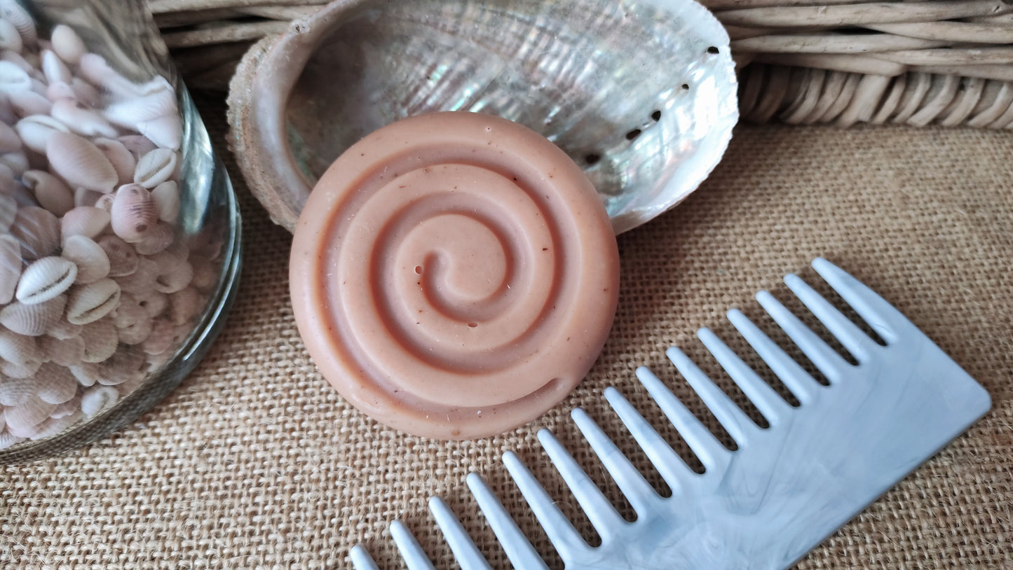 peigne à grandes dents présenté à côté d'un shampooing solide