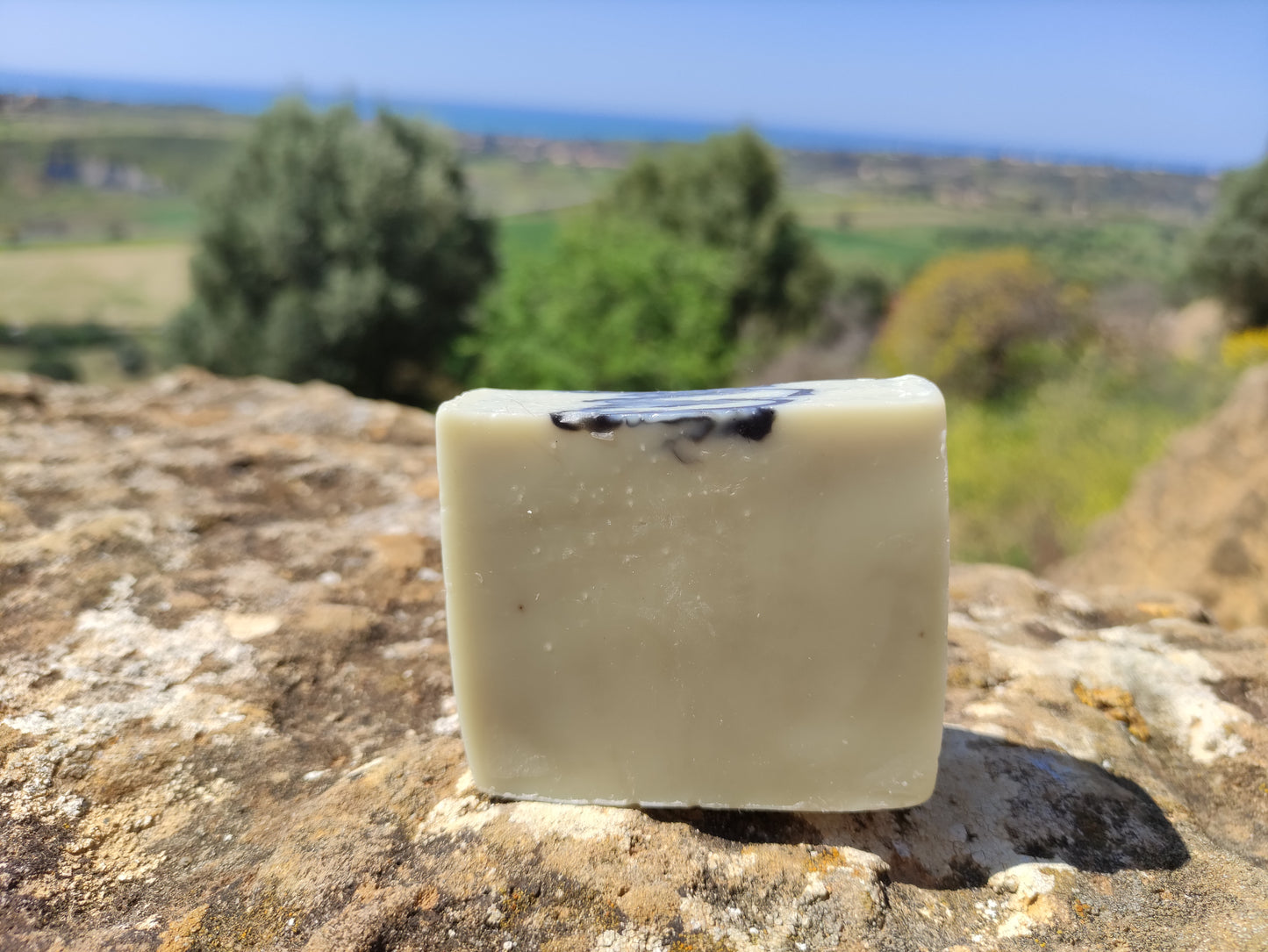 Savon saponifié à froid à l'huile de baies de laurier et à la lavande posé un rocher sur les hauteurs de syracuse