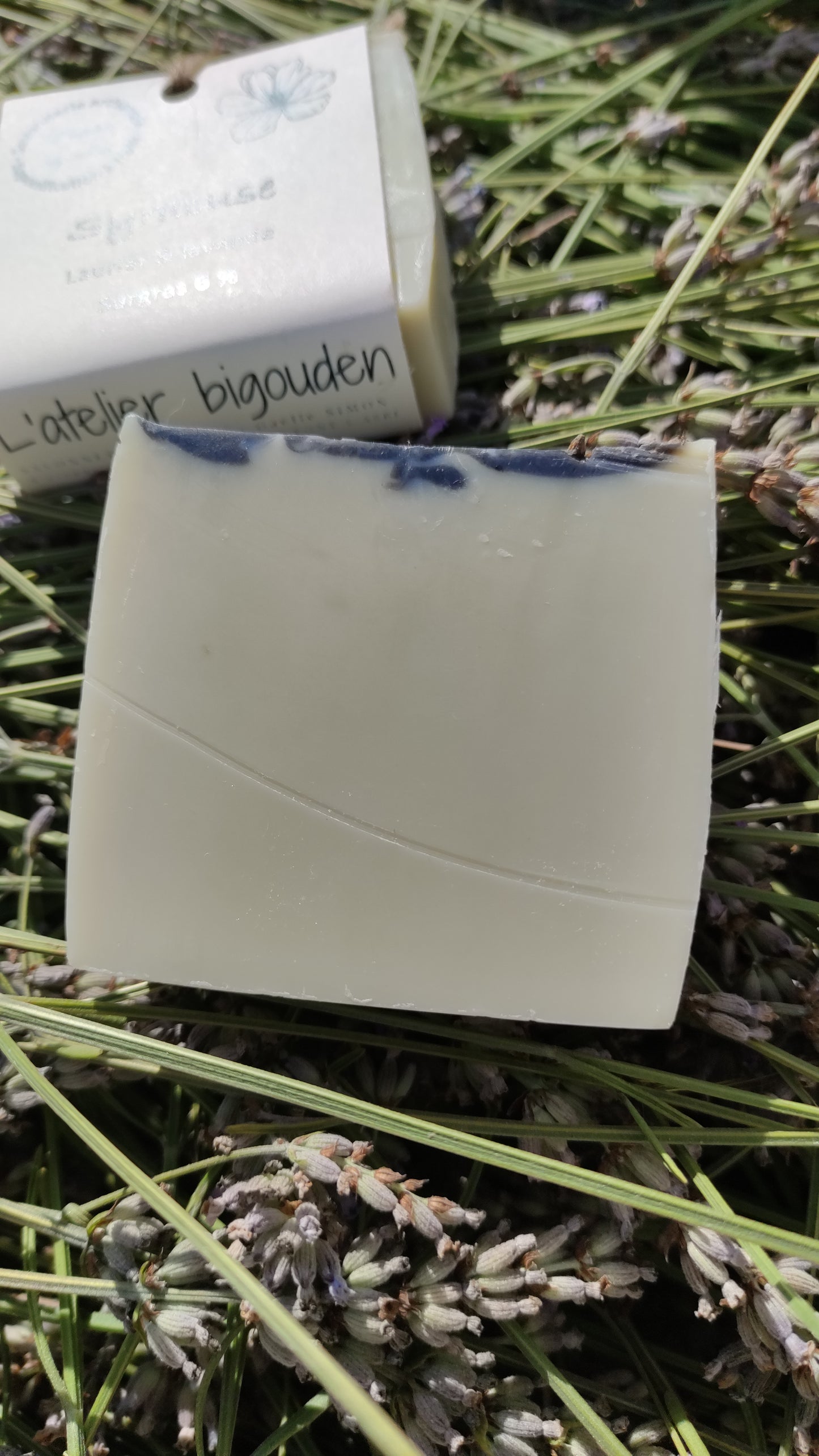 Savon saponifié à froid à l'huile de baies de laurier et à la lavande posé sur de la lavande fraichement coupée