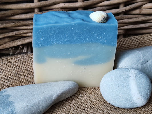 Savon saponifié à froid avec des dégradés bleus et blancs rappelant la mer. Un coquillage blanc est posé dessus