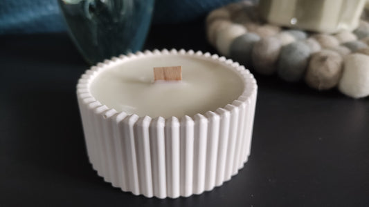 Bougie non parfumée dans un support rond strié blanc en jesmonite, mèche en bois