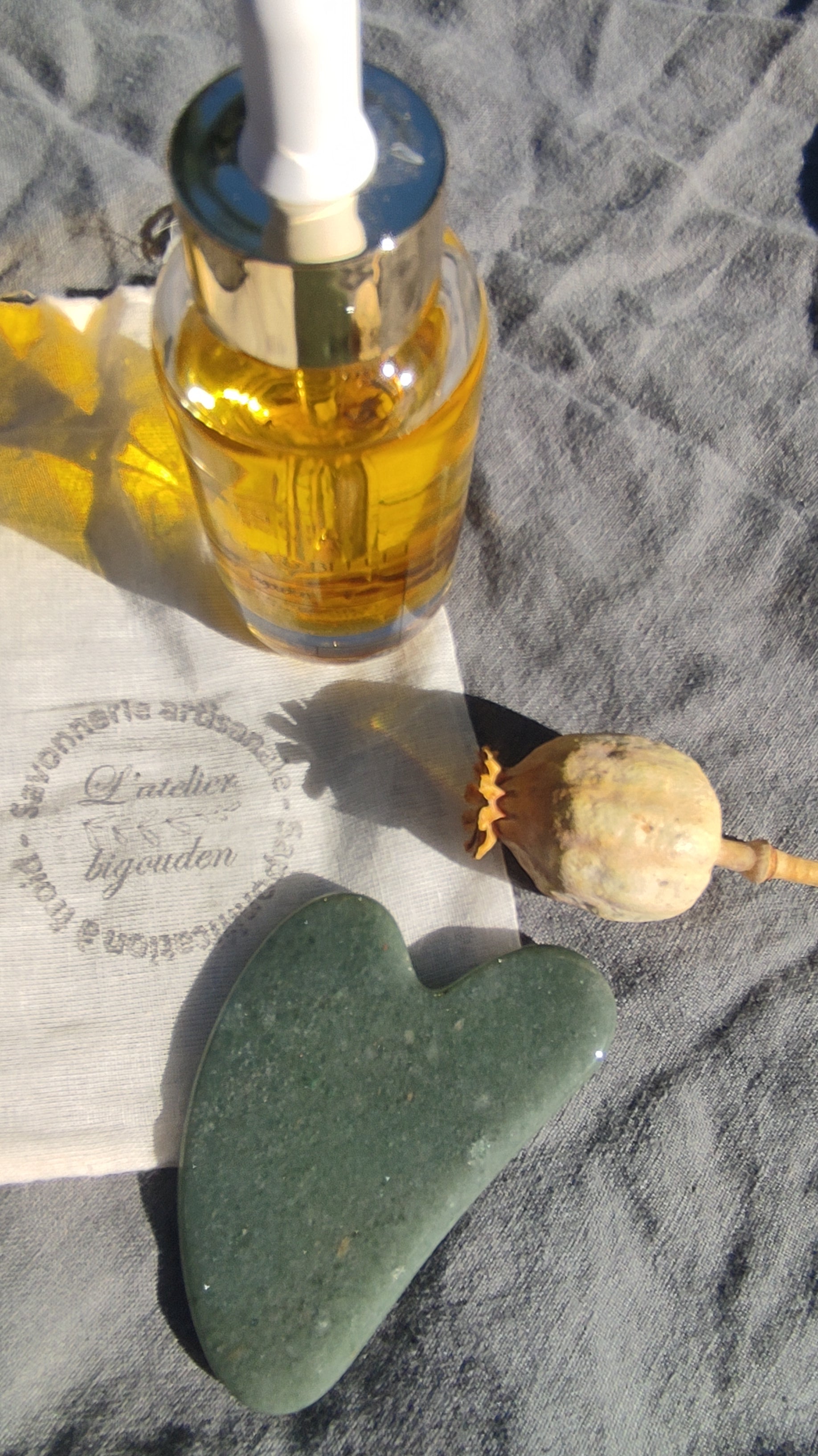 coffret comprenant une huile sèche visage, corps et cheveux de 50 mL à base d'un macérât de fleurs et d'un gua sha en pierre pour le massage du visage