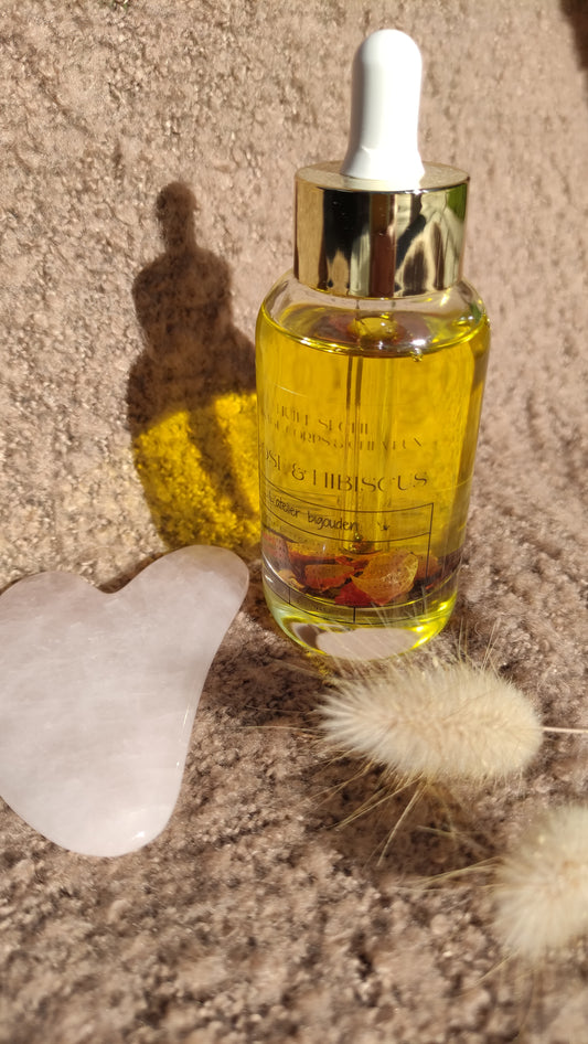 coffret comprenant une huile sèche visage, corps et cheveux de 50 mL à base d'un macérât de fleurs et d'un gua sha en pierre pour le massage du visage