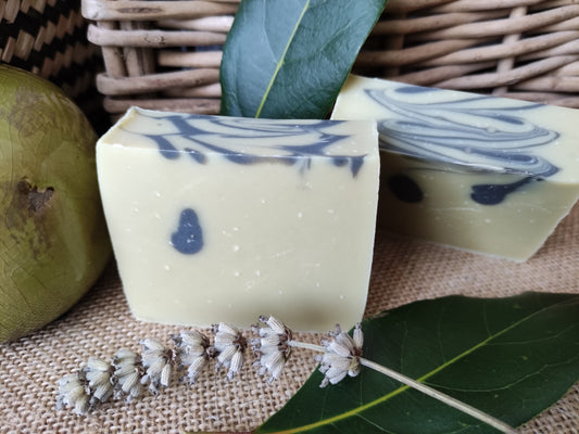 Savon saponifié à froid à l'huile de baies de laurier et à la lavande avec feuille de laurier et brin de lavande posés à côté